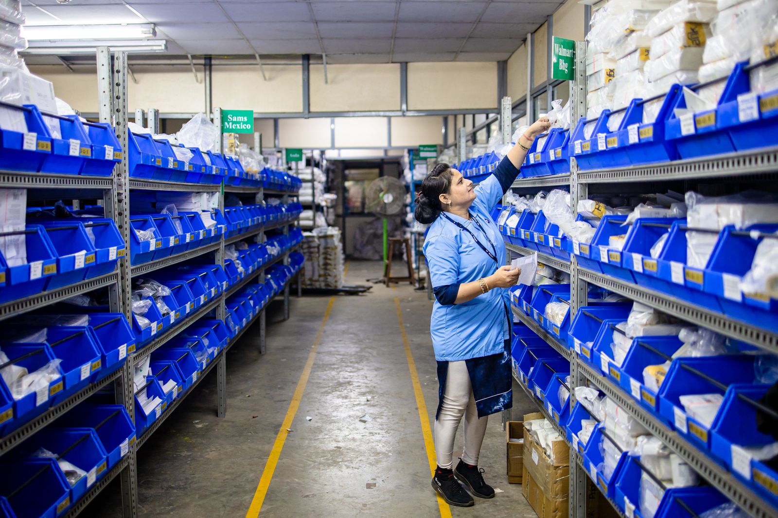 Operator picking items from blue storage bins