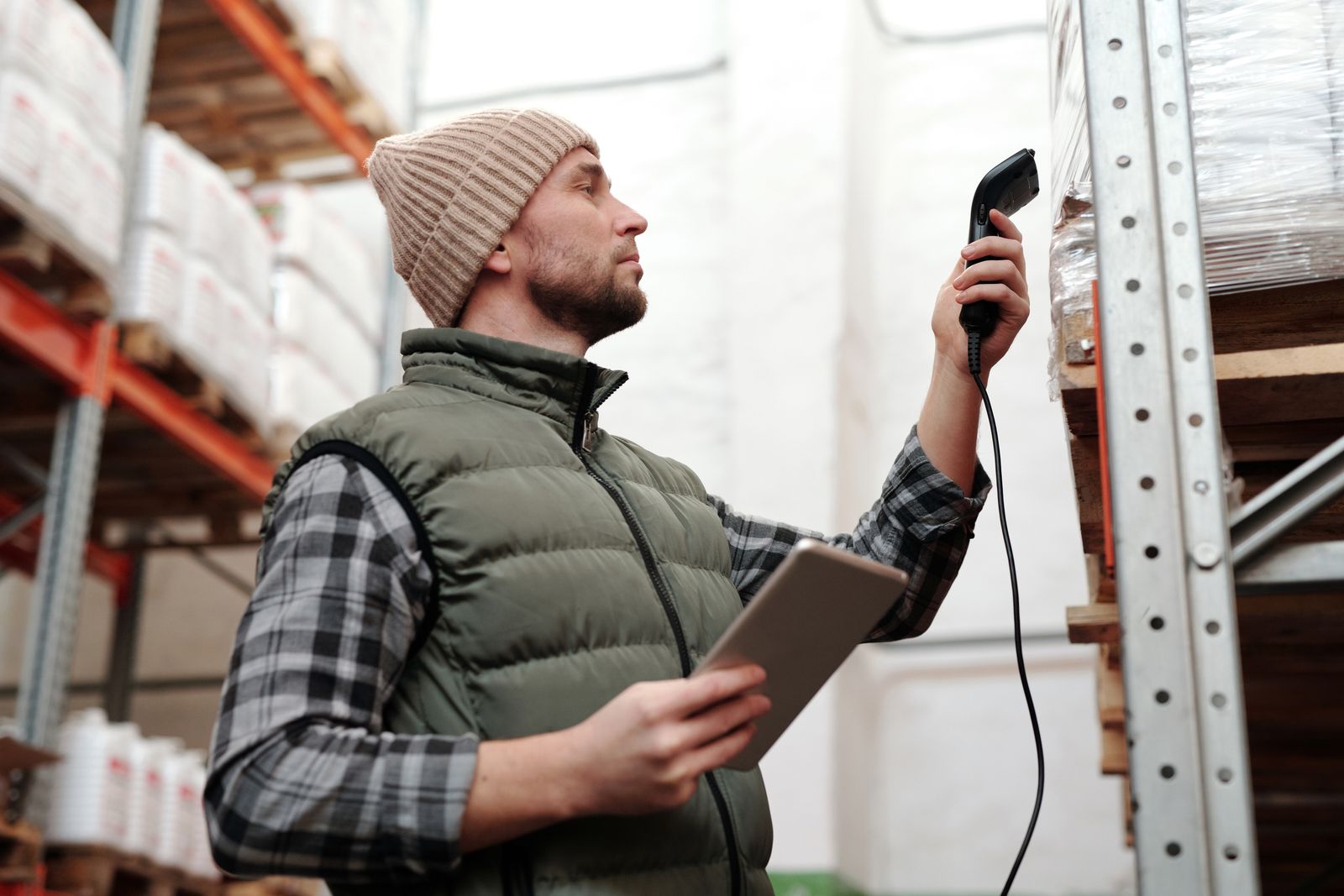 Warehouse operator scanning stock with a handheld scanner and tablet